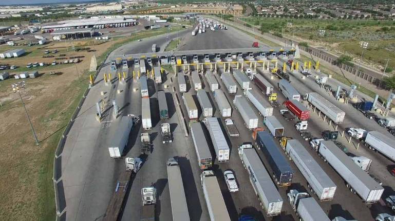 A large group of trucks parked at a toll booth, symbolizing Mexico's economic growth and transportation infrastructure.